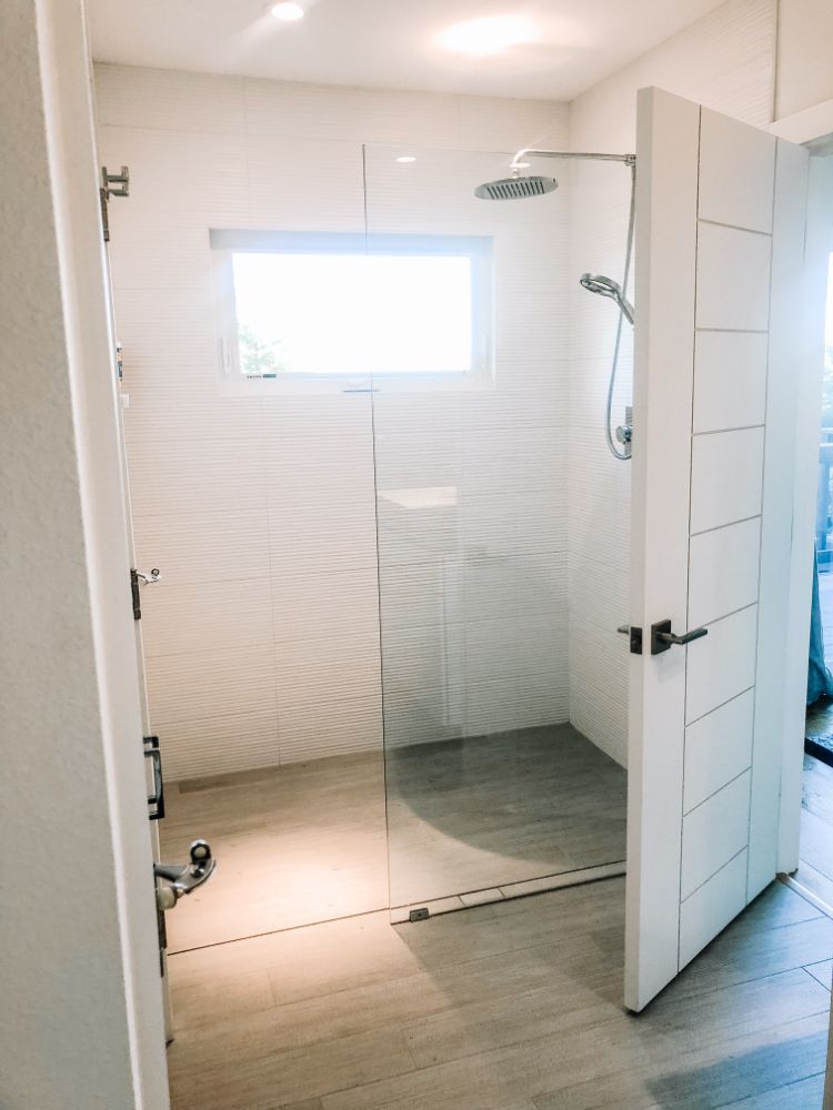 modern white bathroom with glass shower wall