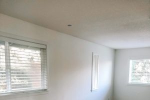 large empty room with white walls and medium brown hardwood floors