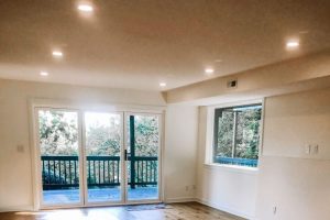 clean empty room with white walls and knotty pine hardwood floors