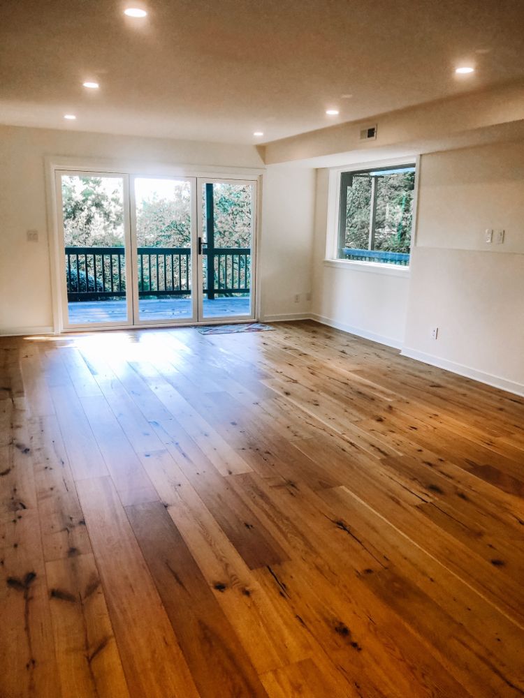 clean empty room with white walls and knotty pine hardwood floors