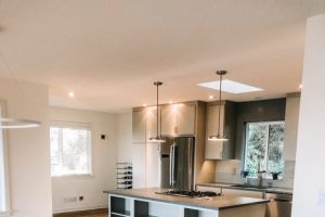 empty clean kitchen with grays and whites with light wide plank hardwood