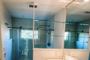 bathroom with double sinks and glass shower