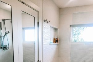 modern shower with glass wall and mirrored doors