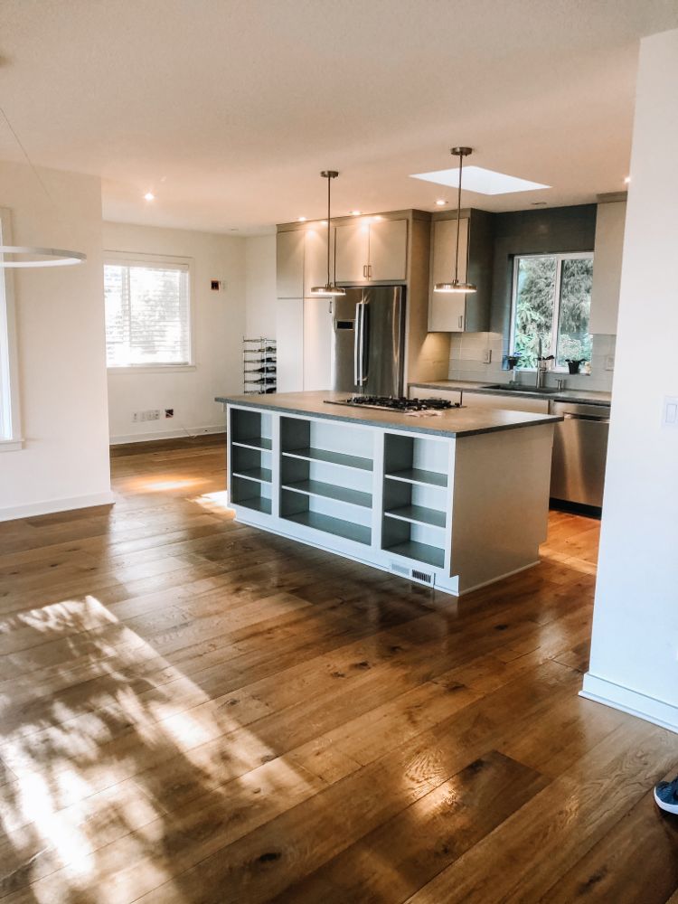 empty clean kitchen with grays and whites with light wide plank hardwood