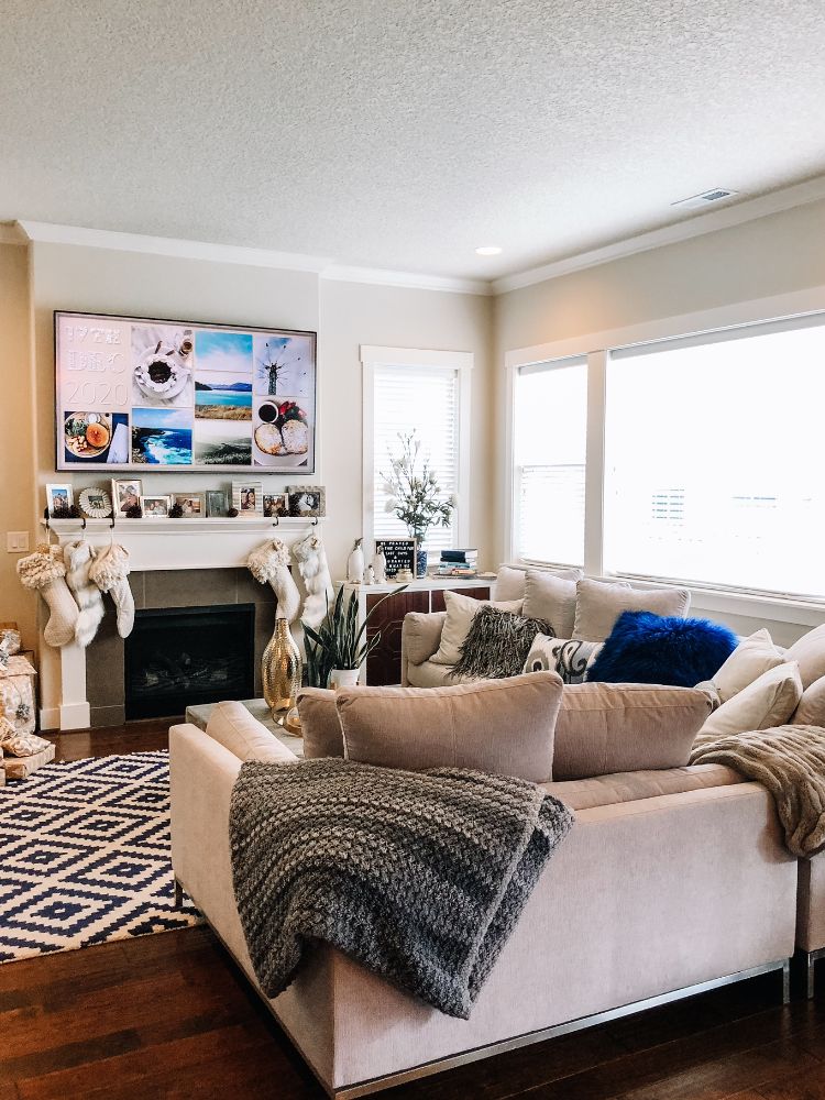 cozy modern tan and white living room with lots of pillows and fireplace