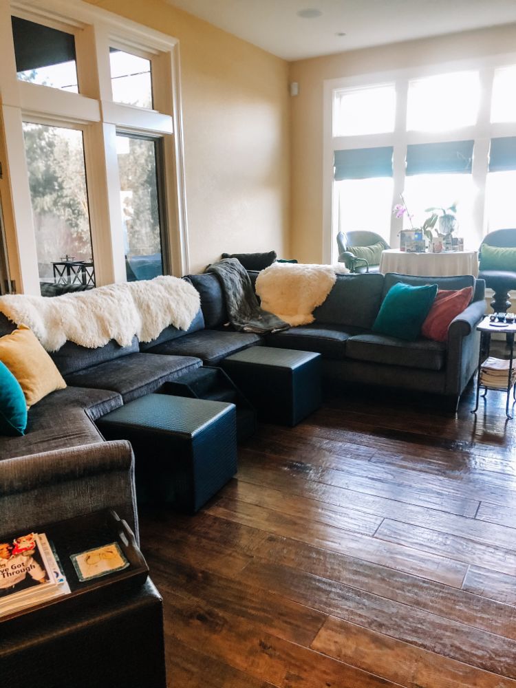 clean living room with lots of blankets and rustic hardwood floors