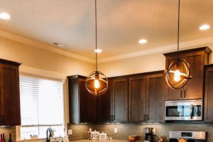 dark cabinets with granite countertops and white leather chairs