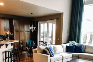 open layout with tan couch and rich brown hardwood floors