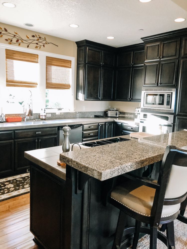 clean kitchen with black cabinets and granite countertops